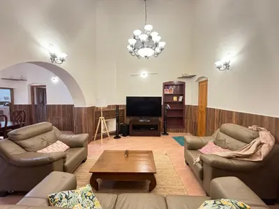 a living room with two couches and a coffee table at Wyncroft Bed and Breakfast, Heritage Bungalow at Kotagiri in Kotagiri