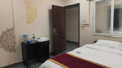 a hotel room with a bed and a window at Shri Bhagawathi Residency in Palani