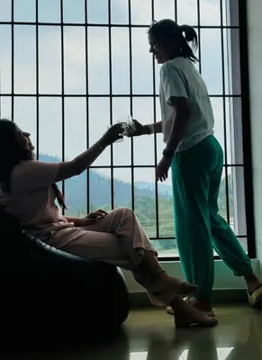 two women standing in front of a window at Hestia chalet 3BHK near Ooty lake in Ooty