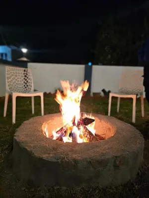 a fire pit in a yard at night with two chairs at Hestia chalet 3BHK near Ooty lake in Ooty