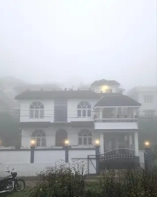 a house in the fog with a motorcycle in front of it at Hestia chalet 3BHK near Ooty lake in Ooty