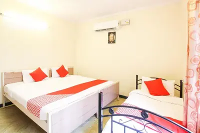 a bedroom with a bed with red pillows at Hotel O Kingston Residency in Vānivilāsa Puram