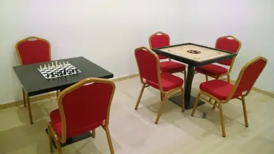 a group of chairs and a table with a chess board on it at Hotel Vijay Elanza in Coimbatore