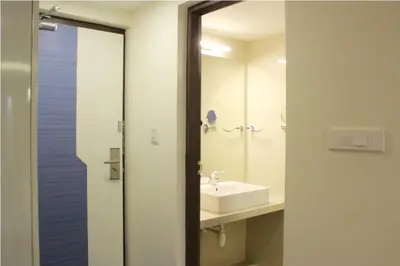 a bathroom with a sink and a mirror at Hotel Vijay Elanza in Coimbatore