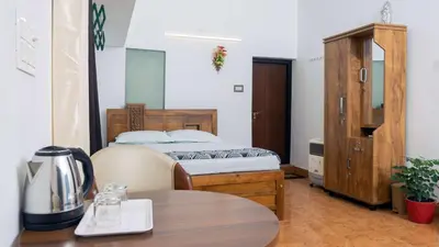 a small bedroom with a bed and a table at Nest Nature Homestay in Kalpetta