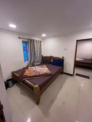 a bedroom with a bed in a room with a mirror at VR cottage in Ooty