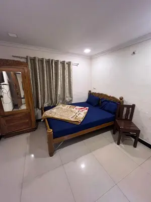 a bedroom with a blue bed and a chair at VR cottage in Ooty