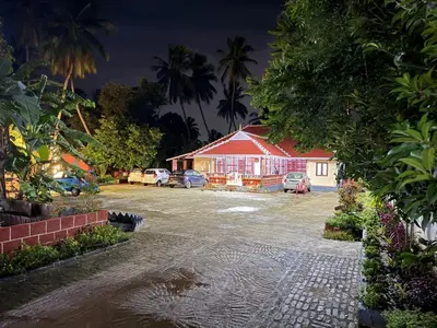a parking lot in front of a house at night at Essaar Punnot Farmstay Resort in Kollengode