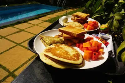 a plate of breakfast food with toast and fruit at Viharana Spa and Resorts in Ooty