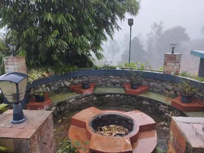 a stone patio with a fire pit in a garden at Viharana Spa and Resorts in Ooty