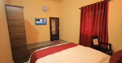 a bedroom with a bed and a red curtain at Hamai town villa in Ambalavayal