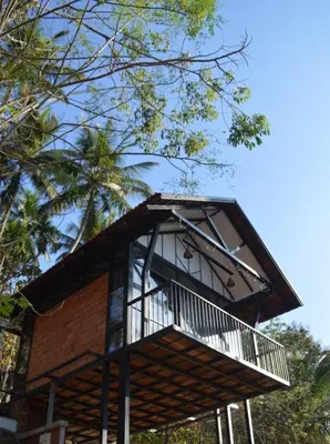 a tree house with a balcony on top of it at Waterfall View Stay Chappanthotam Kozhikode in Kuttyādi