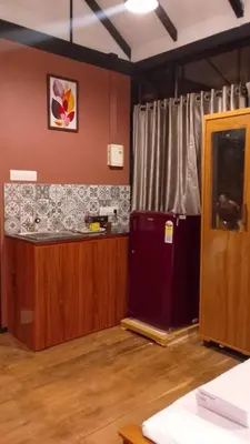 a room with a kitchen with a counter and a refrigerator at Waterfall View Stay Chappanthotam Kozhikode in Kuttyādi