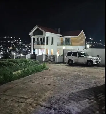 a white truck parked in front of a house at night at Palazzo Villa in Ooty