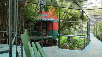 a green house with a building inside of it at Bamboo Planet Resort in Vythiri