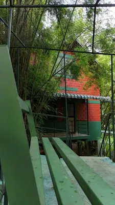 a green bench in front of a building at Bamboo Planet Resort in Vythiri