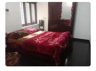 a bedroom with a bed with a red blanket on it at Dream Home in Irimbranallūr