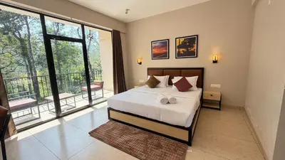 a bedroom with a large bed and a balcony at Coorg Homes in Madikeri