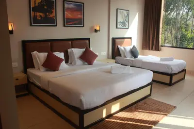 a hotel room with two beds in a bedroom at Coorg Homes in Madikeri