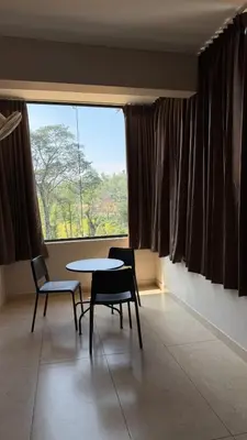 a room with a table and two chairs and a window at Coorg Homes in Madikeri