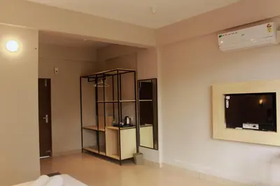 a living room with a tv on a wall at Coorg Homes in Madikeri