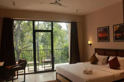 a bedroom with a bed and a balcony with a large window at Coorg Homes in Madikeri