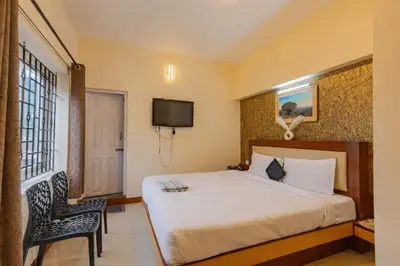 a hotel room with a bed and a tv at Pentoz Hotels Boutique Stay Near Botanical Garden Ooty in Ooty