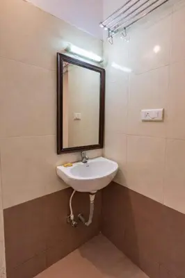 a bathroom with a sink and a mirror at Pentoz Hotels Boutique Stay Near Botanical Garden Ooty in Ooty
