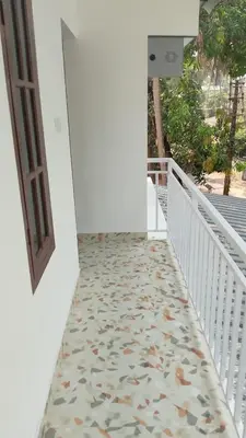 a hallway with a tile floor and a door at Krishna stays in Manattala
