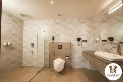 a bathroom with a toilet and a sink at Nilayat Inn in Ollur
