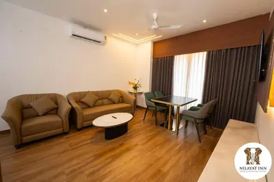 a living room with a couch and a table at Nilayat Inn in Ollur