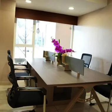 an office with a large wooden table with chairs and flowers at Nilayat Inn in Ollur