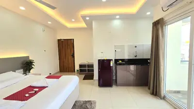 a large bedroom with a large bed and a kitchen at Hi-Fi Service Apartment in Mysore