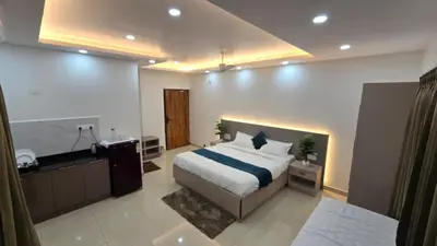 a bedroom with a large bed and a bathroom at Hi-Fi Service Apartment in Mysore