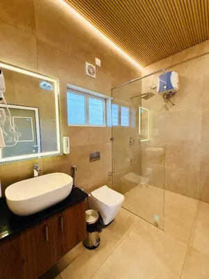 a bathroom with a toilet and a sink and a shower at Manayath Wayanad Premium Pool Resort in Wayanad
