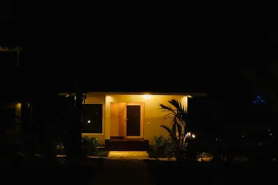 a small house with a door at night at Manayath Wayanad Premium Pool Resort in Wayanad
