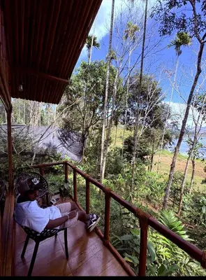 two people sitting on a porch looking at the ocean at carpa lupa 1 waterfront bamboo cottage wayanad in Meenangadi