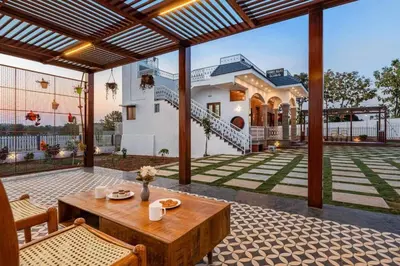 an outdoor patio with a table and a house at White Meadows Mysore in Mysore