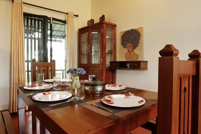a wooden table with plates on it in a room at House StoneHaven in Kaniyāmbetta