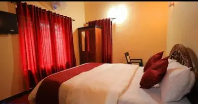 a bedroom with a bed with red curtains at Hamai town villa in Ambalavayal