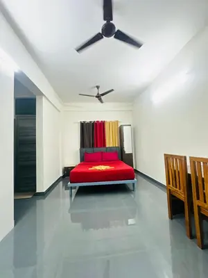 a bedroom with a red bed and a ceiling fan at Silver Gate Rooms in Kozhikode