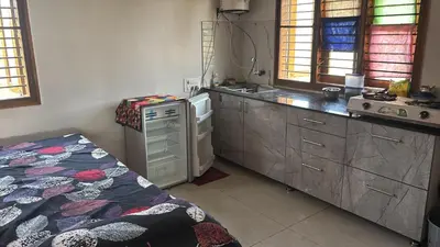 a kitchen with a bed and a sink and a stove at Free Private Room with Body Massage in Mysore