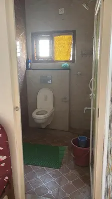 a small bathroom with a toilet and a window at Free Private Room with Body Massage in Mysore