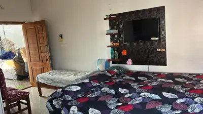 a bedroom with a bed and a tv on the wall at Free Private Room with Body Massage in Mysore