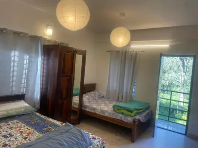 a bedroom with two twin beds and two lamps at Easters home in Kotagiri