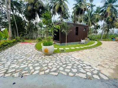a house with a large pot in the middle of a yard at Rajarajeshwari Farm Stay in Sivasamudram