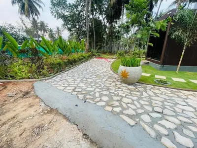 a garden with a stone walkway with a plant at Rajarajeshwari Farm Stay in Sivasamudram