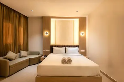 a bedroom with a large bed and a couch at The Continental Suites in Kozhikode