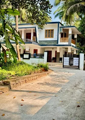 a house with a palm tree in front of it at Sawan Homestay in Tāzhekkod