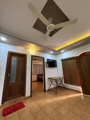 a living room with a ceiling fan and a door at Sawan Homestay in Tāzhekkod